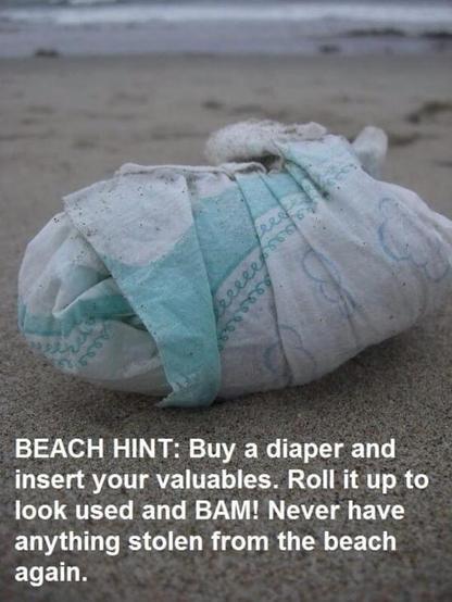 A beach scene with a baby diaper message reminding people to take their valuables with them to the beach.