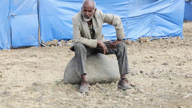 Haile Tsege, 76, sits on a rock in the Sebacare internally displaced persons (IDPs) camp, on the outskirts of Mekele, Tigray region, Ethiopia, Wednesday, Feb. 12, 2025. (AP Photo/Alexander Mamo)