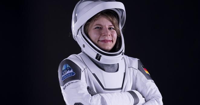 TU Alumna Rabea Rogge trägt einen Raumanzug sowie einen Helm mit offenen Visier