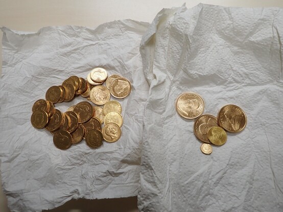 Auf Küchenpapier liegen mehrere Goldmünzen.