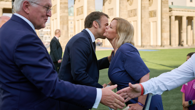 Bundesinnen- und Sportministerin Nancy Faeser und der französische Präsident Emmanuel Macron begrüßen sich.
