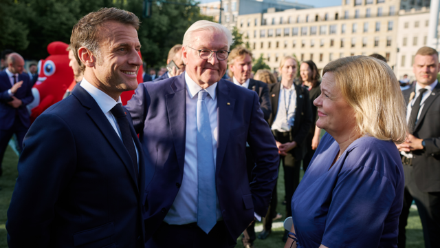 Bundesinnen- und Sportministerin Nancy Faeser, Bundespräsident Frank-Walter Steinmeier und der französische Präsident Emmanuel Macron im Gespräch vor dem Brandenburger Tor.