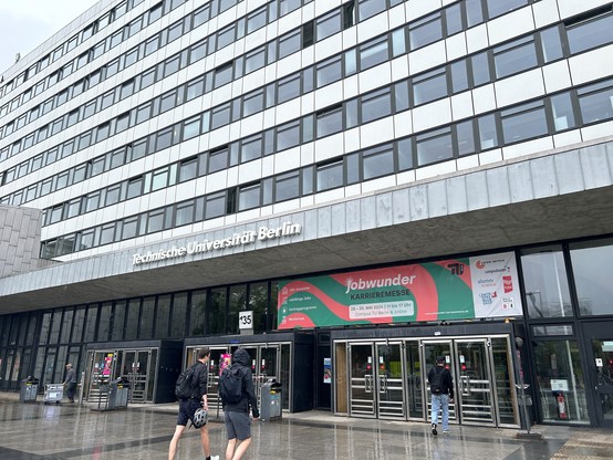 Ein Foto vom Eingang zum TU-Hauptgebäude mit einem großen Banner der JobWunder. Aufgenommen am 28. Mai 2024.