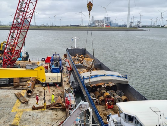 Blick von der Brücke der Barge auf das Arbeitsdeck (links). Per Kran wird gerade eine weitere Stahlrolle rechts seitlich auf ein Binnenschiff umgeladen.
📸 WSV/brand Marine Consultants GmbH