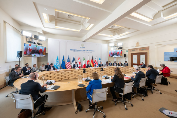 Konferenzraum. Am Tisch sitzen die Innenministerinnen und -Minister sowie weitere Vertreter der Partner sowie 