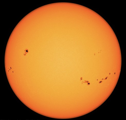 Die ganze erdzugewandte Seite der Sonne in gelber und am Rand leicht orangeroter Farbe. Rechts unterhalb des Äquators eine Gruppe von neun oder zehn Sonnenflecken. Auch links oberhalb des Äquators ein Sonnenfleck, der deutlich größer ist und der sich in den letzten Tagen infolge der Sonnenrotation mehr und mehr in unsere Richtung gedreht hat. Diese Sonnenflecken korrespondieren oft mit den Aktiven Regionen, wie sie auch kürzlich für die starken Eruptionen verantwortlich sind. Denn beide sind die Folgen von Störungen in den komplizierten Magnetfeldern der Sonne, die plötzlich Teilchenströme und auch Strahlung freisetzen.