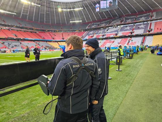 Zwei Mitarbeiter der Bundesnetzagentur überprüfen im Stadion mit Messgeräten die genutzten Frequenzen.