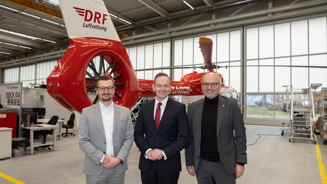 © Christiane Haumann-Frietsch. Bei seinem Besuch der Deutschen Luftrettung erhält Volker Wissing einen Rundgang durch die verschiedenen Räumlichkeiten. Ein Mitarbeiter stellt ihm das Kontrollzentrum vor, welches mit Bildschirmen ausgestattet ist.