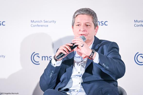 BSI-Präsidentin Claudia Plattner sitzt mit Mikrofon in der Hand auf einem Panel der Munich Security Conference.
