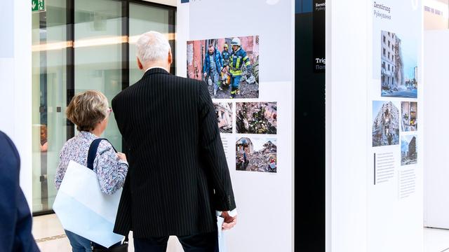 Zwei Menschen schauen sich in der Portikushalle Fotografien auf schlichten, hellen Ausstellungswänden an.