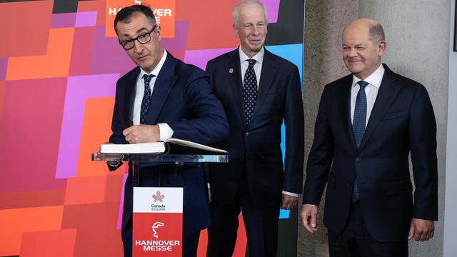 Bundesforschungsminister Cem Özdemir trägt sich in das Gästebuch der Hannover Messe ein. Daneben stehen Stéphane Dion, Canadian Special Envoy to the European Union und Bundeskanzler Olaf Scholz.